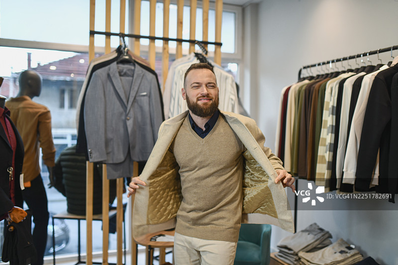 男人在时尚店里试穿西装和夹克，开心地跳舞图片素材