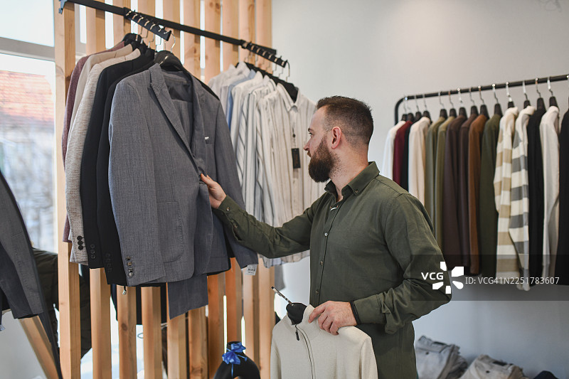 男士在服装店浏览西装和外套，试穿夹克图片素材