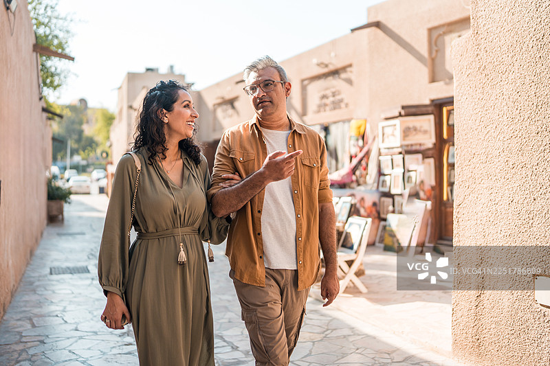 在中东夫妇在黄金时刻的光线下漫步于历史街区图片素材