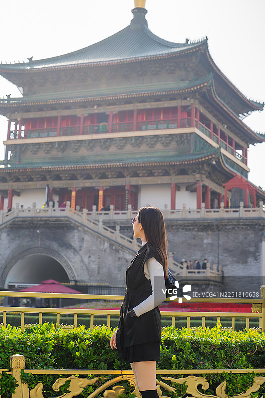 女子在中国历史钟楼前摆姿势图片素材