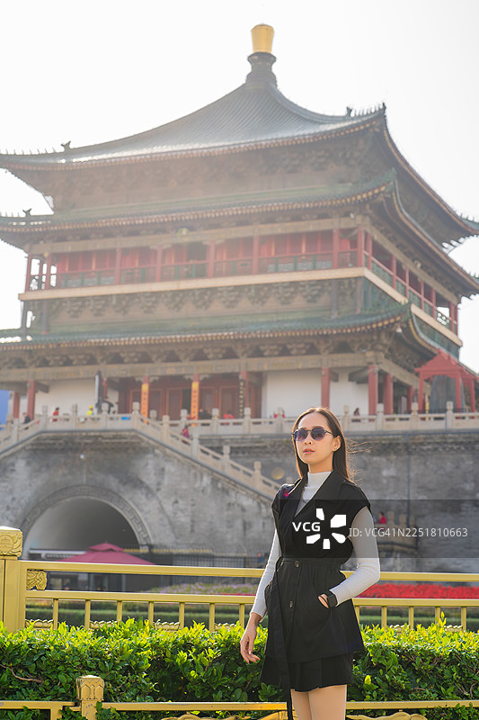 身着古装的女子在中国古代钟楼前摆姿势图片素材