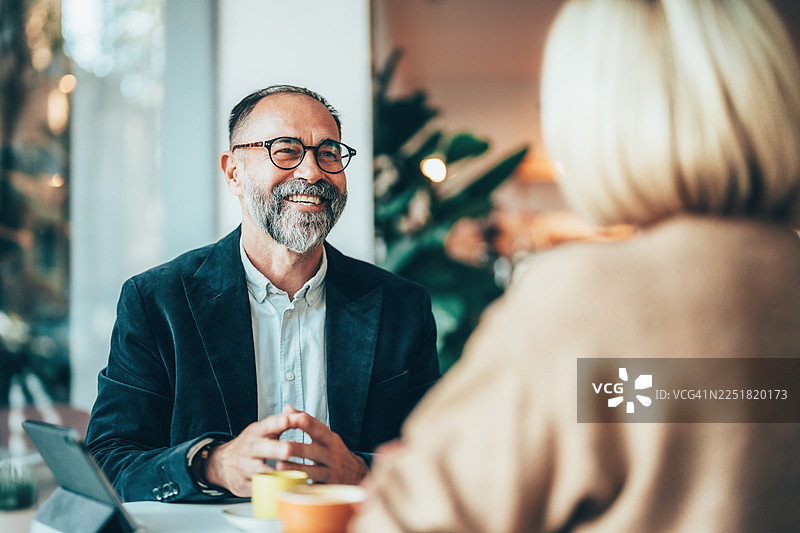 资深专业人士在咖啡馆举行非正式商务会议图片素材