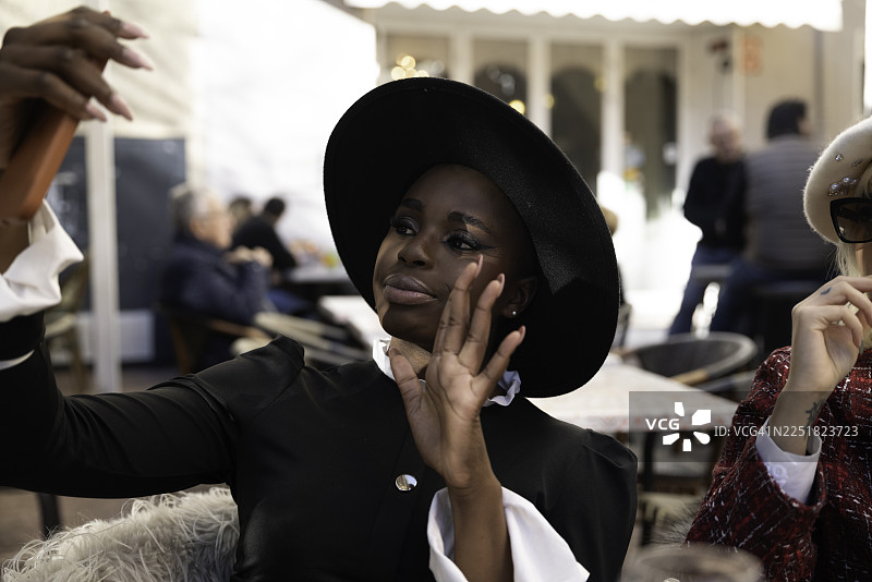 法国蔚蓝海岸一家咖啡馆露台上优雅的女子在自拍图片素材