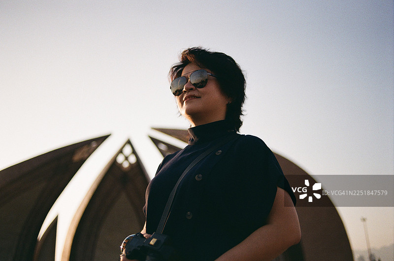 一位亚洲女性自信地站在伊斯兰堡的巴基斯坦纪念碑前，被记录在胶片上图片素材