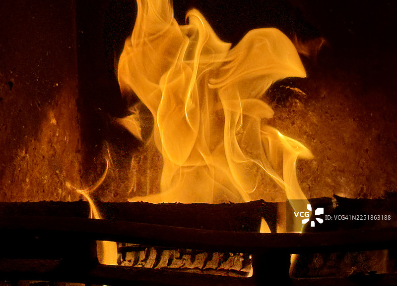 壁炉中敞开的煤炭和木材燃烧的火焰，特写镜头图片素材