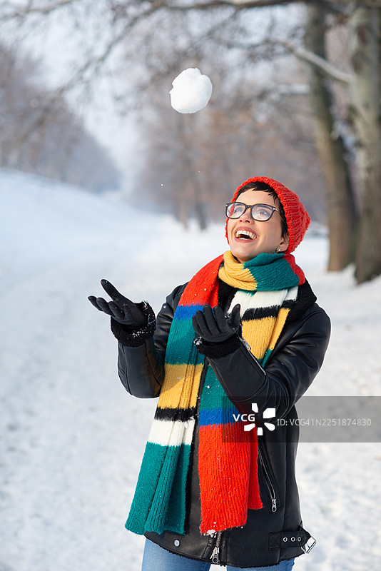 年轻的女士微笑着在冬天的雪地里玩耍图片素材