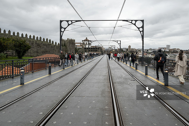 行人走在葡萄牙波尔图的唐路易斯一世大桥上图片素材