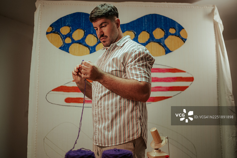 男艺术家手工编织抽象挂毯图片素材