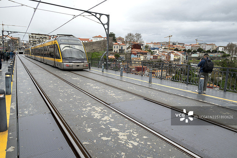 唐路易一世大桥上的游客和行人，一列波尔图地铁列车正经过图片素材