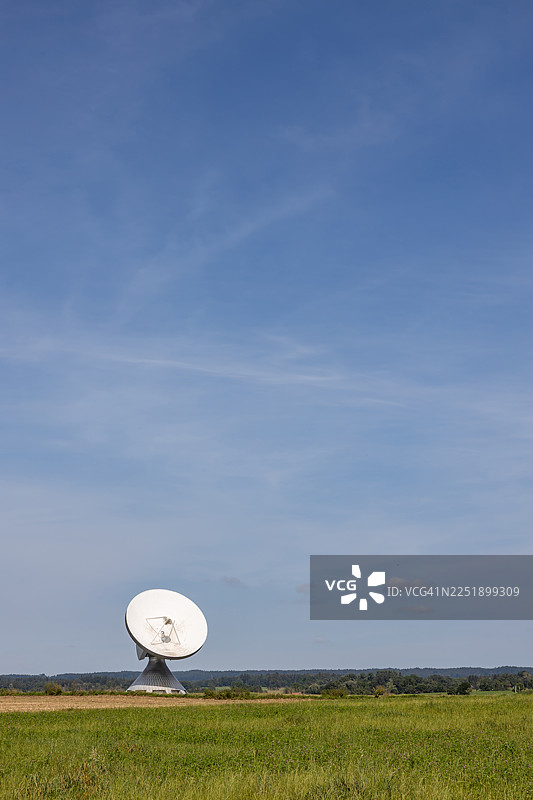 大抛物面天线在自然环境中，背景为蓝天图片素材