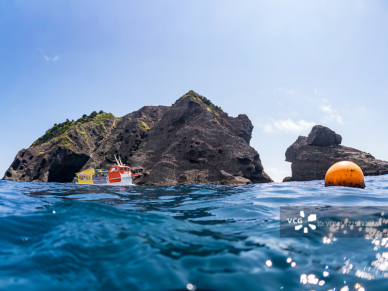 观光船驶离栗滨海滩海岸的半水景镜头。图片素材
