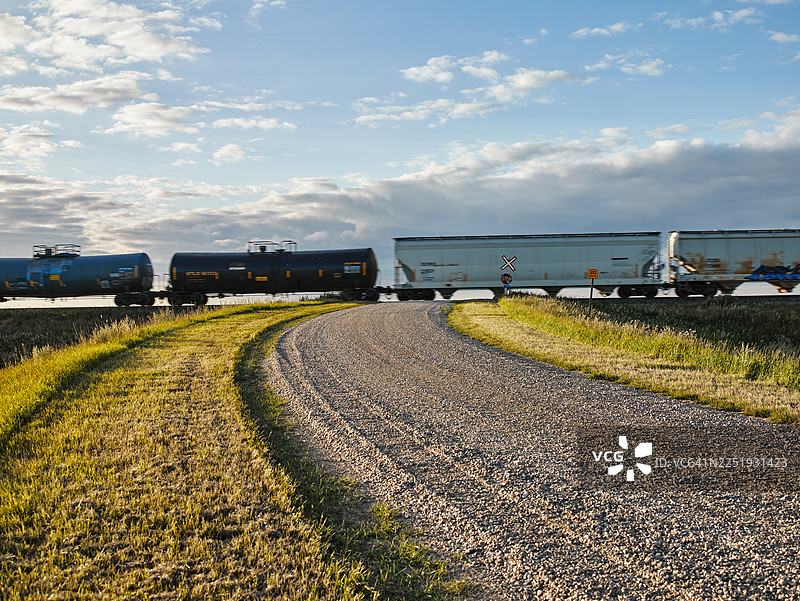 货运火车穿过乡村砂石路图片素材