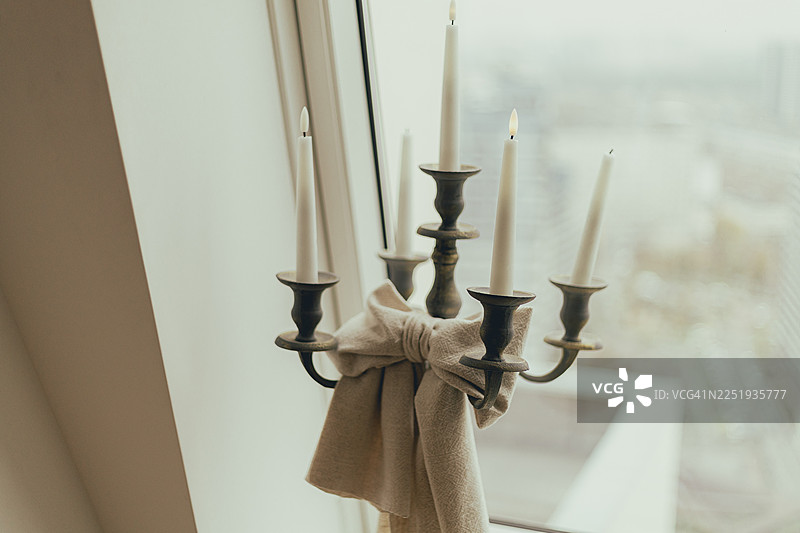模糊的窗户旁，烛台和亚麻蝴蝶结的特写。图片素材