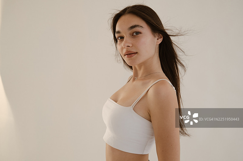 阳光下，一位皮肤洁净湿润的女性的特写肖像图片素材