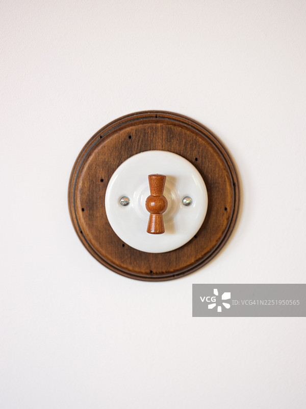 墙上安装的带有木质拨杆的复古电灯开关图片素材