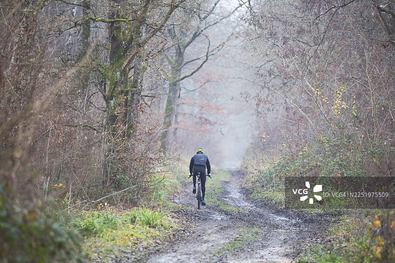 法国森林中骑行者在恶劣天气下的骑行图片素材