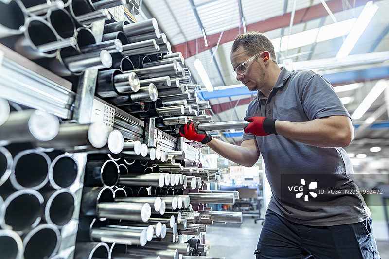 在航空航天零件工厂，工程师从仓库中挑选金属棒图片素材