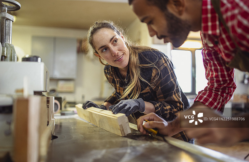 白种女性与男性同事进行引人入胜的木工协作图片素材