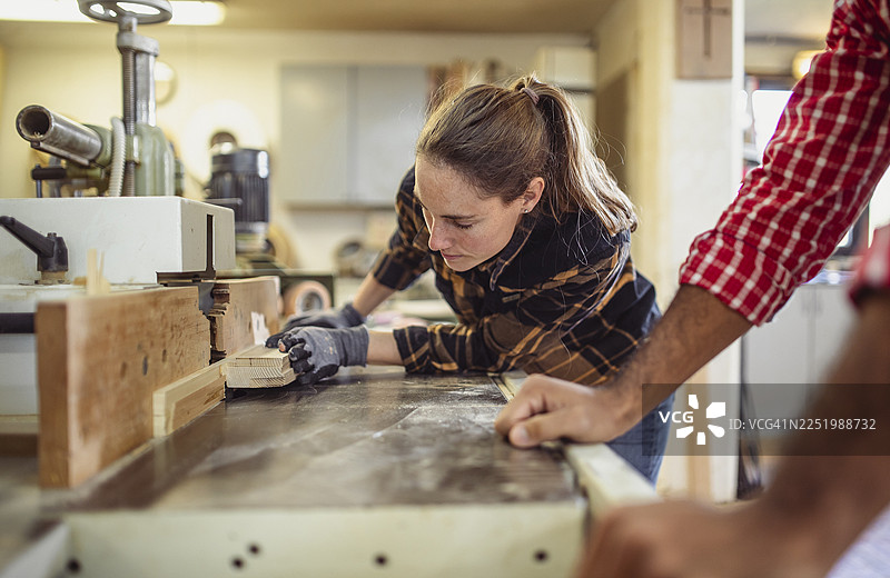 中年白种女性在工作室专注刨木图片素材