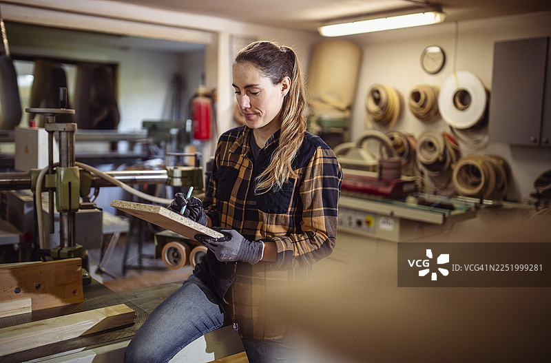 白种女性在木工车间检查木板图片素材