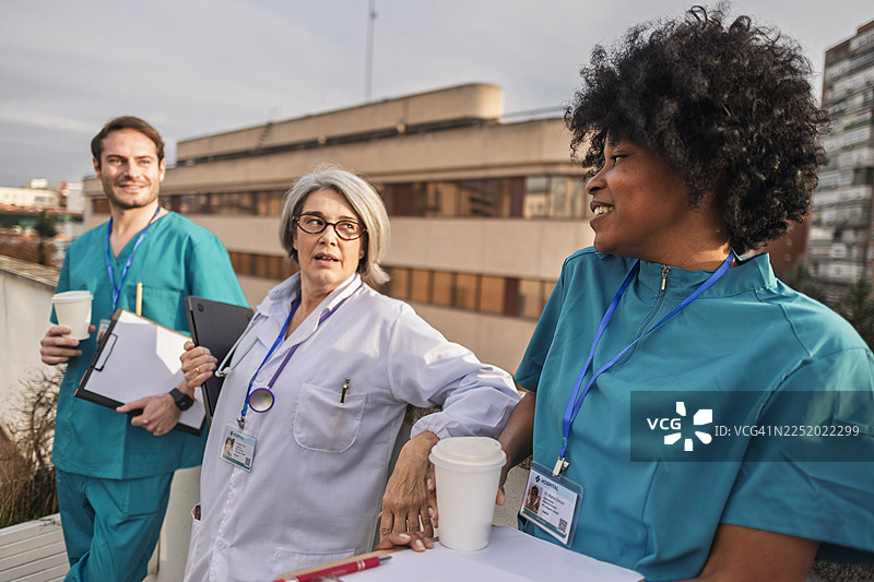 不同背景的医务人员在户外休息并喝咖啡图片素材