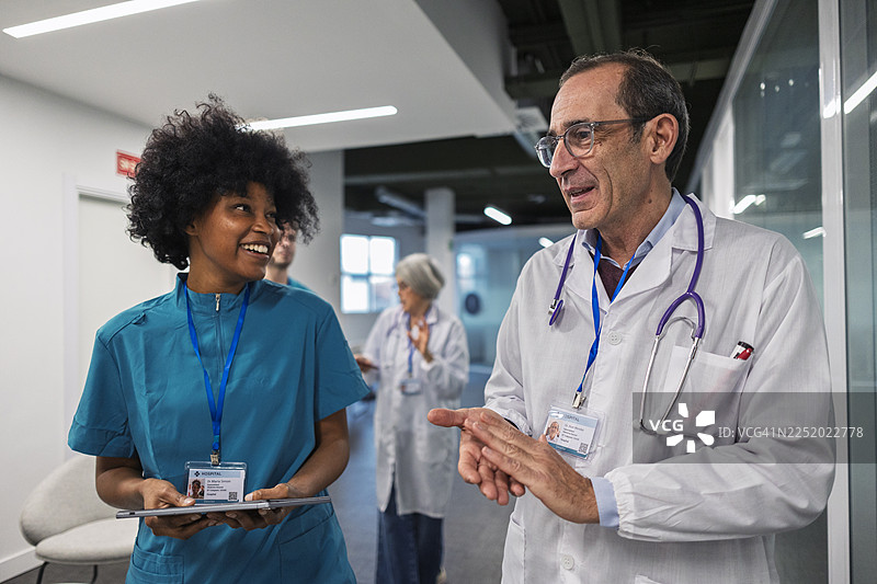 多元化的医疗团队在医院走廊里协作图片素材
