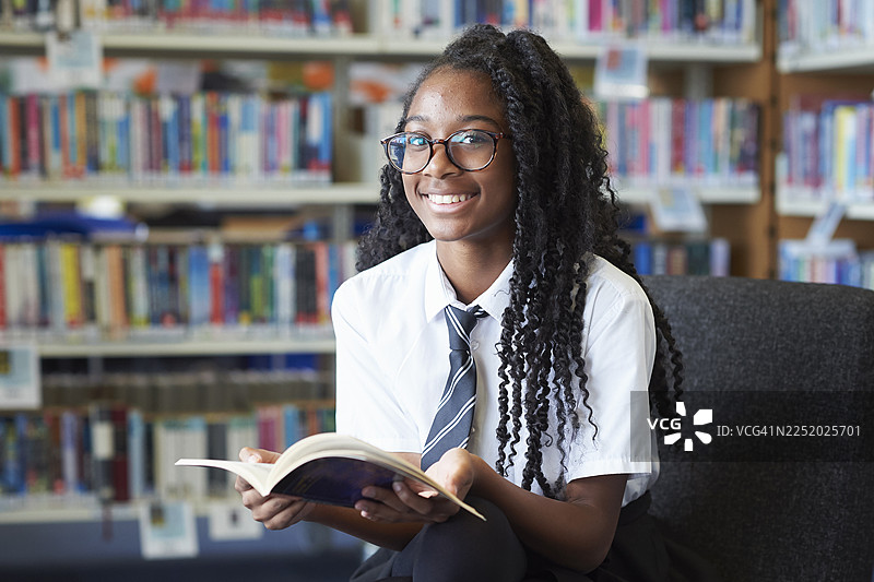 一名女高中生在高中图书馆里读书的肖像图片素材