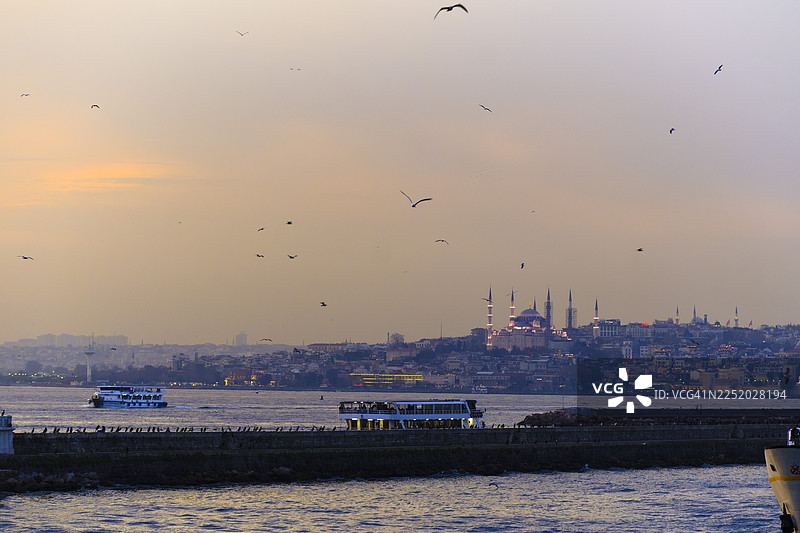 伊斯坦布尔博斯普鲁斯海峡的日落，有蓝色清真寺和渡轮图片素材