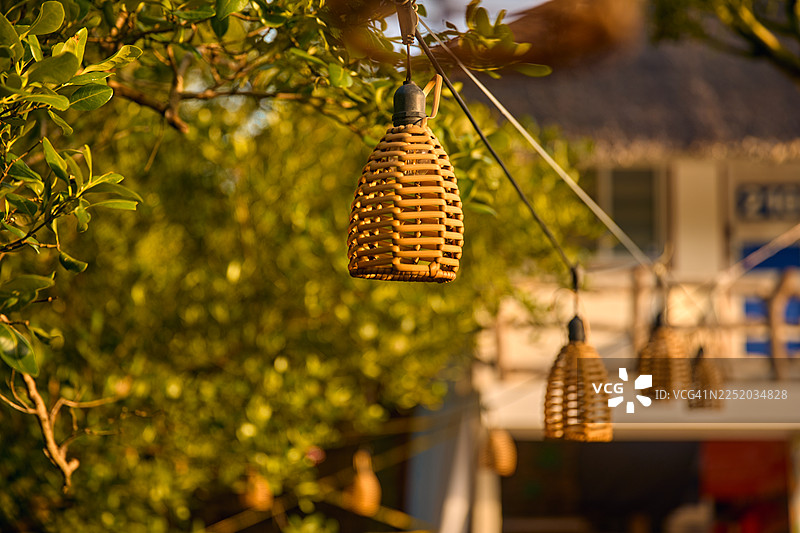 特写镜头，展示带有编织灯罩的小型吊灯。图片素材