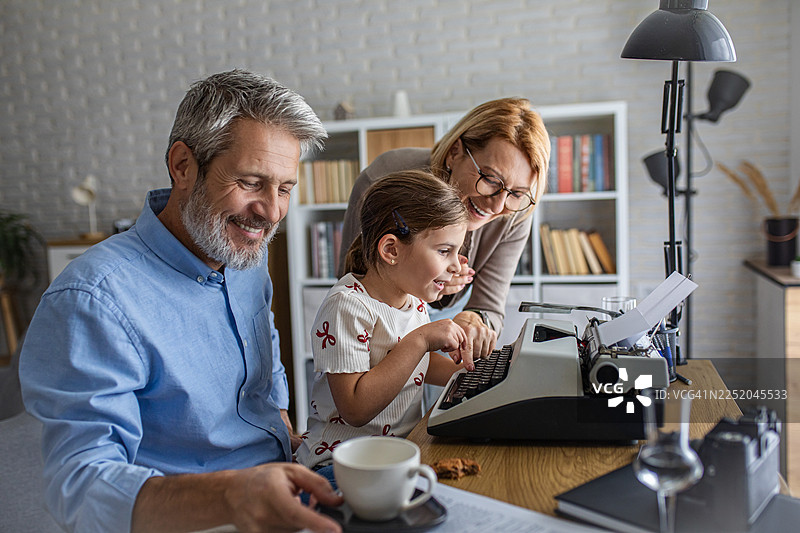 跨越世代的家庭情感联结与老式打字机图片素材