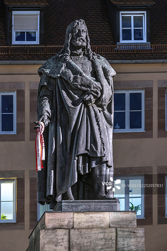 傍晚时分，纽伦堡-中法兰克尼亚-巴伐利亚-德国，阿尔布雷希特·丢勒广场上，阿尔布雷希特·丢勒雕像被灯光照亮图片素材