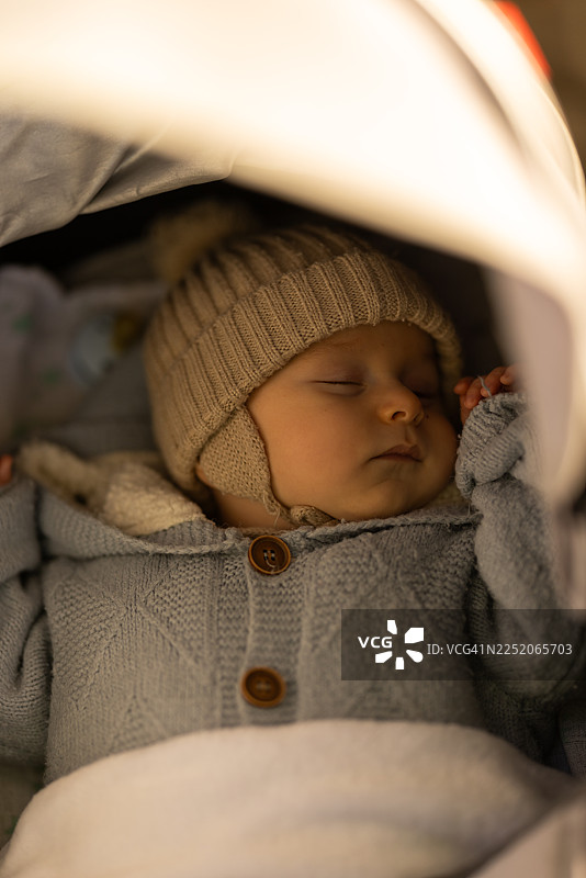 宁静新生儿安睡：温暖舒适的针织毛衣、帽子和柔软毯子，置身于温馨宁静的环境中图片素材