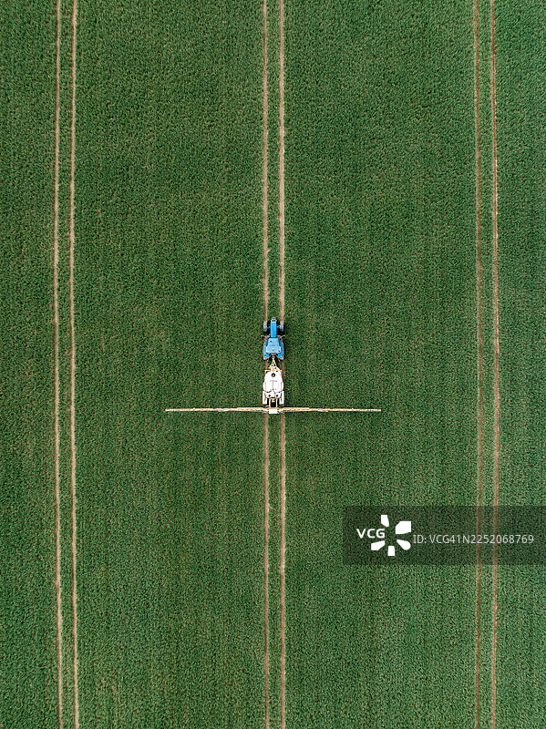 从俯视角度拍摄的拖拉机在英格兰斯塔福德郡的农田里施肥图片素材