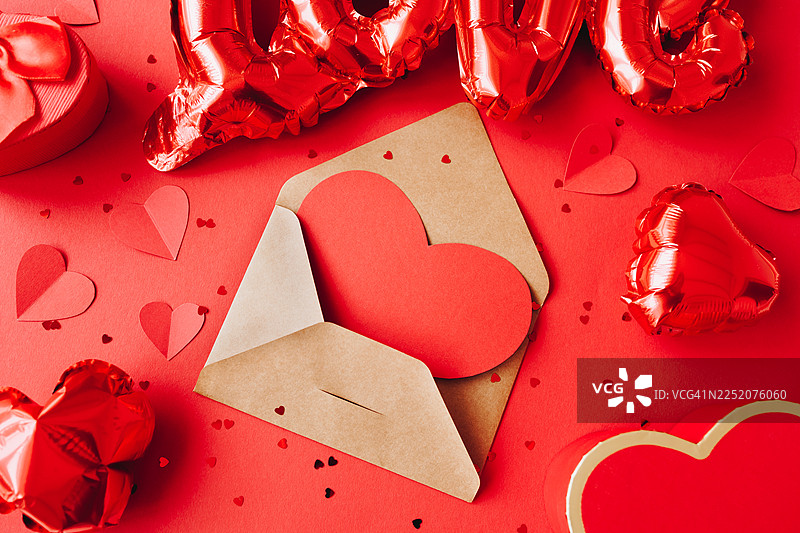 情人节爱心贺卡概念，信封内有纸质心形卡片，背景为红色图片素材