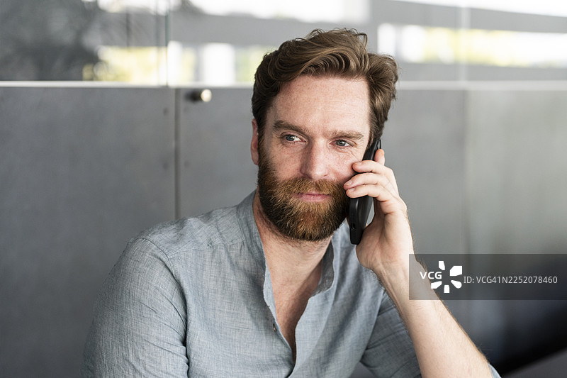 商务人士在办公室用智能手机交谈图片素材