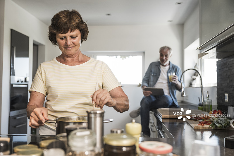 一位年长的女性在家中厨房准备食物图片素材