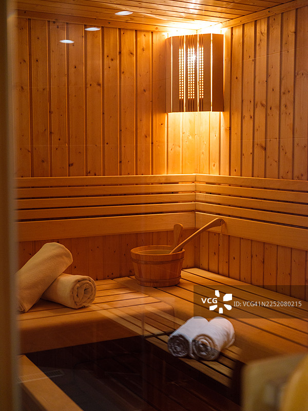 温暖灯光下的木制桑拿房内部，象征着放松与健康图片素材