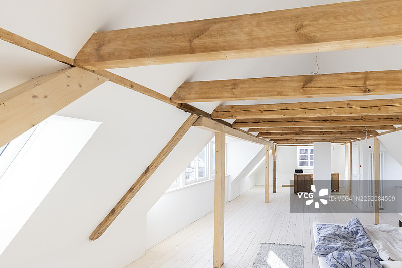正在装修的明亮阁楼，带有木梁和大窗户图片素材