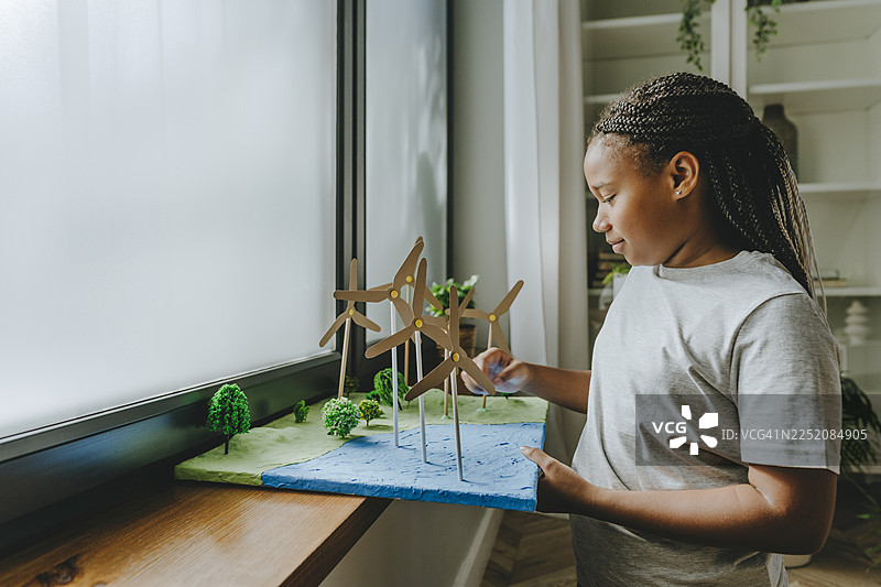 女孩在窗台上准备风力发电机学校项目图片素材
