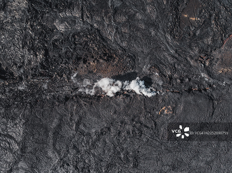 从冰岛雷克雅内斯半岛格林达维克火山喷发后新形成的熔岩上升的烟雾的无人机俯瞰照片图片素材