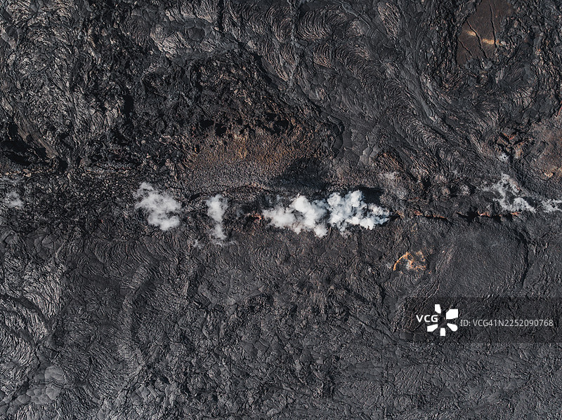 鸟瞰图，显示冰岛雷克雅内斯半岛火山喷发后，熔岩裂缝中升起的烟雾图片素材