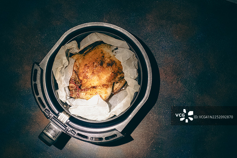 感恩节和圣诞节节日餐桌上用空气炸锅制作的烤鸡或火鸡。图片素材
