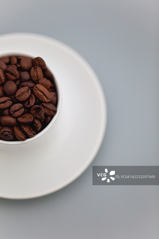 白色杯子和碟子里的烤咖啡豆，留有复制空间图片素材