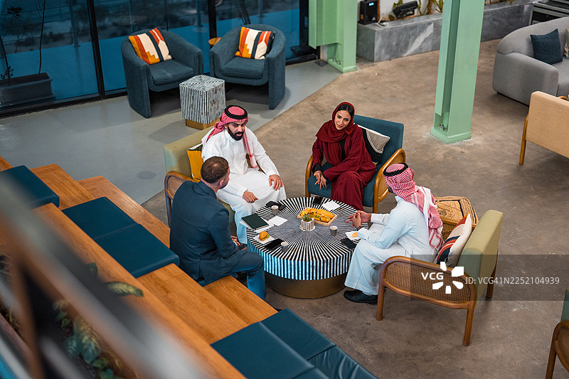 在中东商业专业人士与年轻的白人合作伙伴在现代环境中开会图片素材