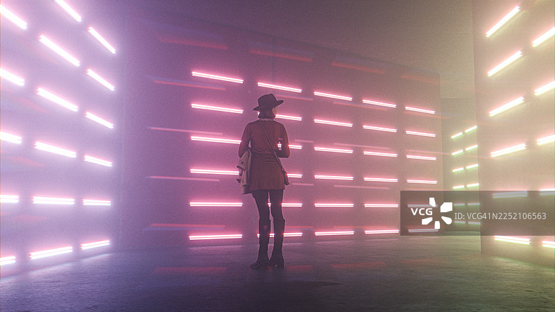 夜晚，年轻女子站在未来派的城市走廊里图片素材