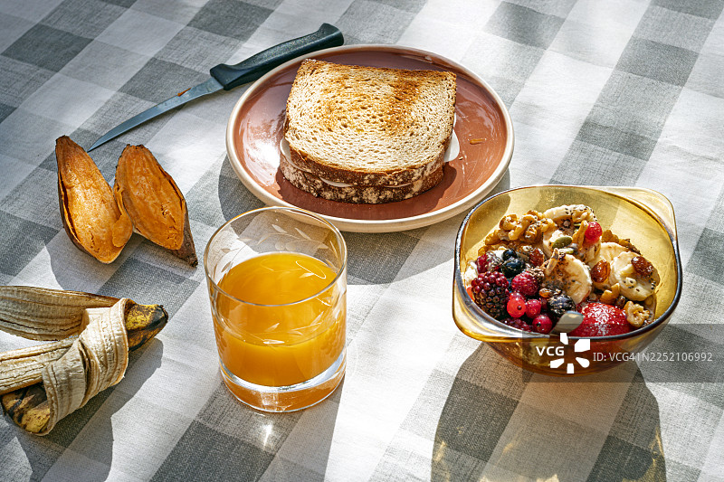水果碗、吐司、红薯和橙汁的健康早餐图片素材