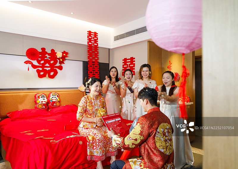 中国广东大湾区，在中国婚礼仪式开始前，新郎在房间里向新娘许下诺言。这是一个充满情感、承诺和亲密婚礼前传统的时刻。图片素材