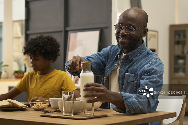 父亲和儿子在厨房一起享用健康的早餐图片素材