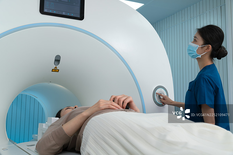 亚洲女护士在医院为老年女患者准备进行核磁共振检查。图片素材
