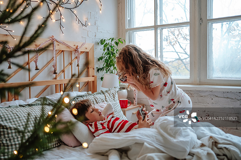孩子们在舒适的卧室里一起庆祝圣诞早晨图片素材
